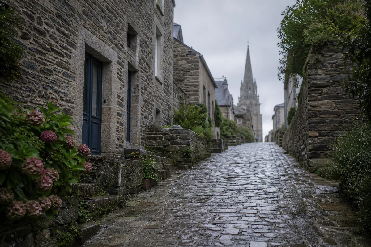 Rue en pente de la Ville Haute de Quimperlé bordée de maisons de schiste et de murets de granit