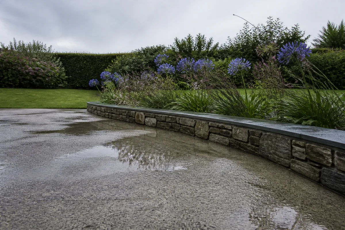 Terrasse en béton désactivé et massif d’agapanthes dans un jardin de bord de mer